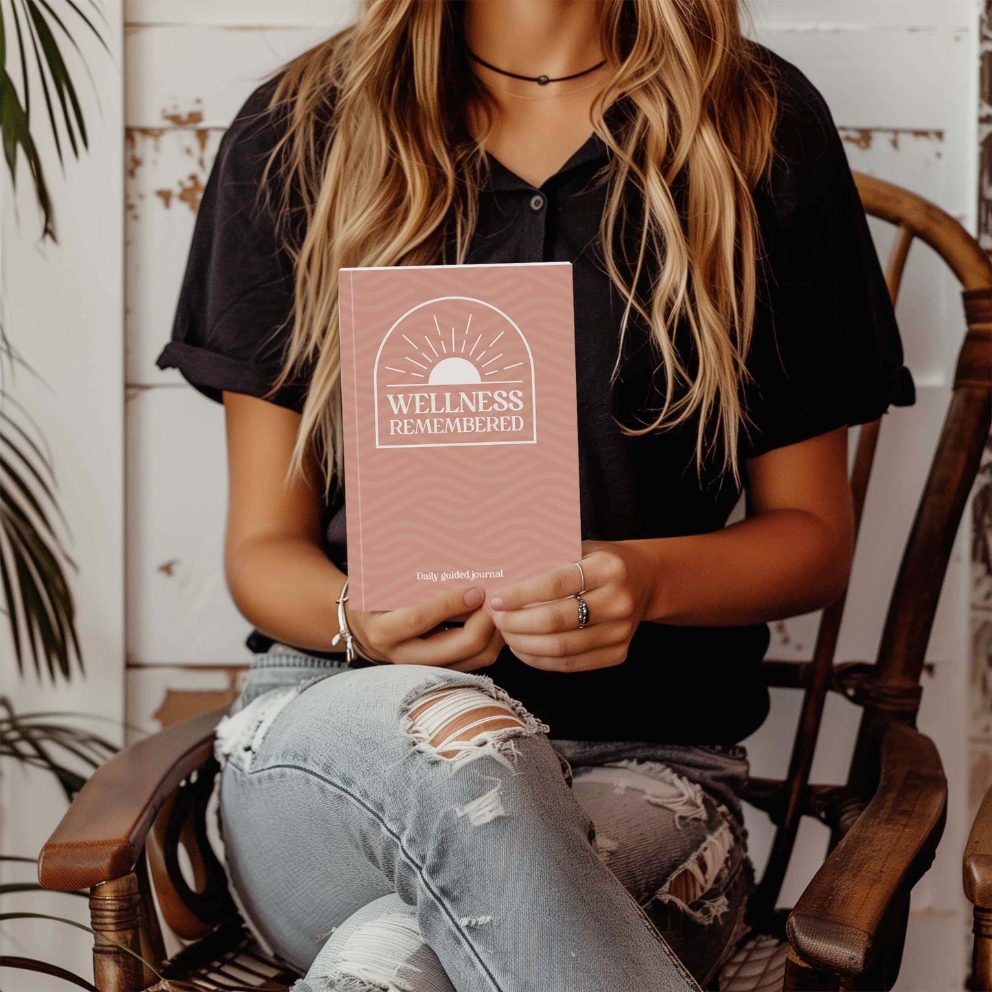 Woman holding the Wellness Remembered Mental Health Journal, showcasing mindfulness and self-improvement.