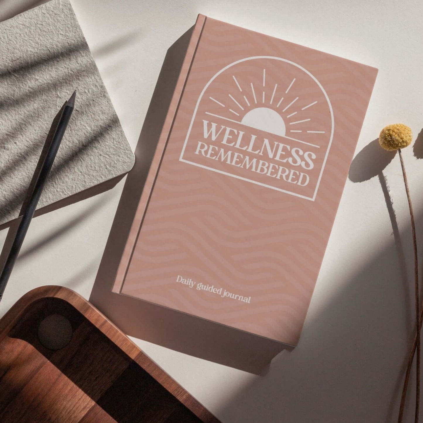 Wellness Remembered Mental Health Journal on wooden table, designed for daily mindfulness and self-improvement.