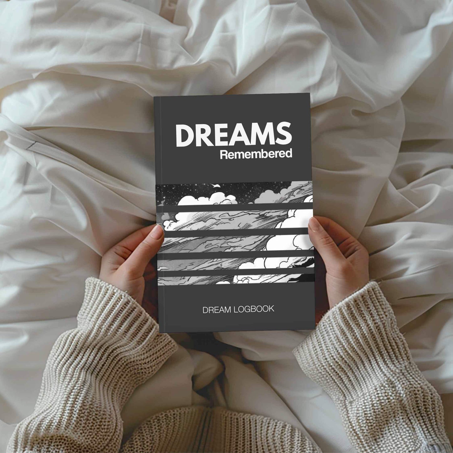 Person holding 'Dreams Remembered' dream logbook on a cozy bed.