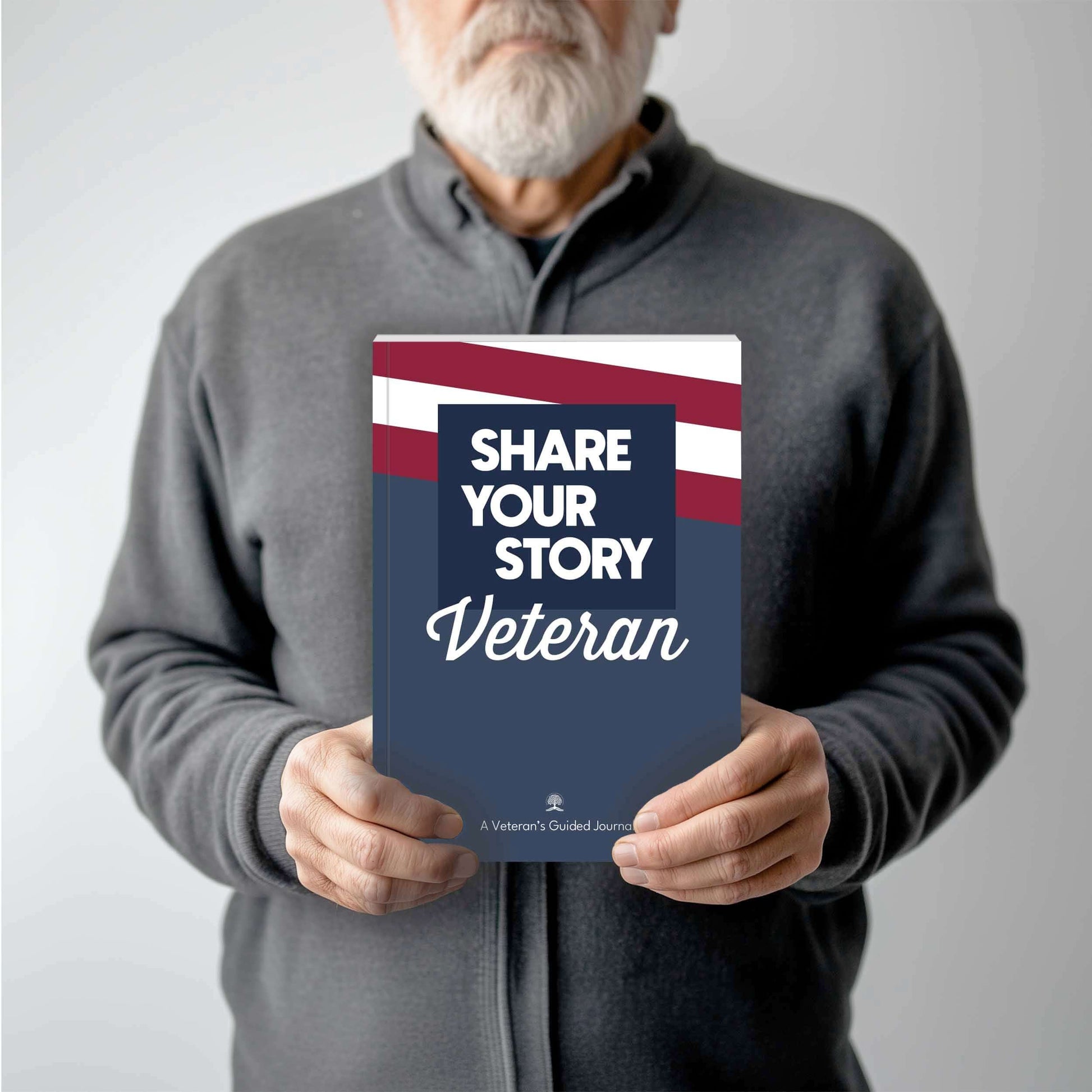 Veteran holding the 'Share Your Story Veteran' guided journal for U.S. veterans.